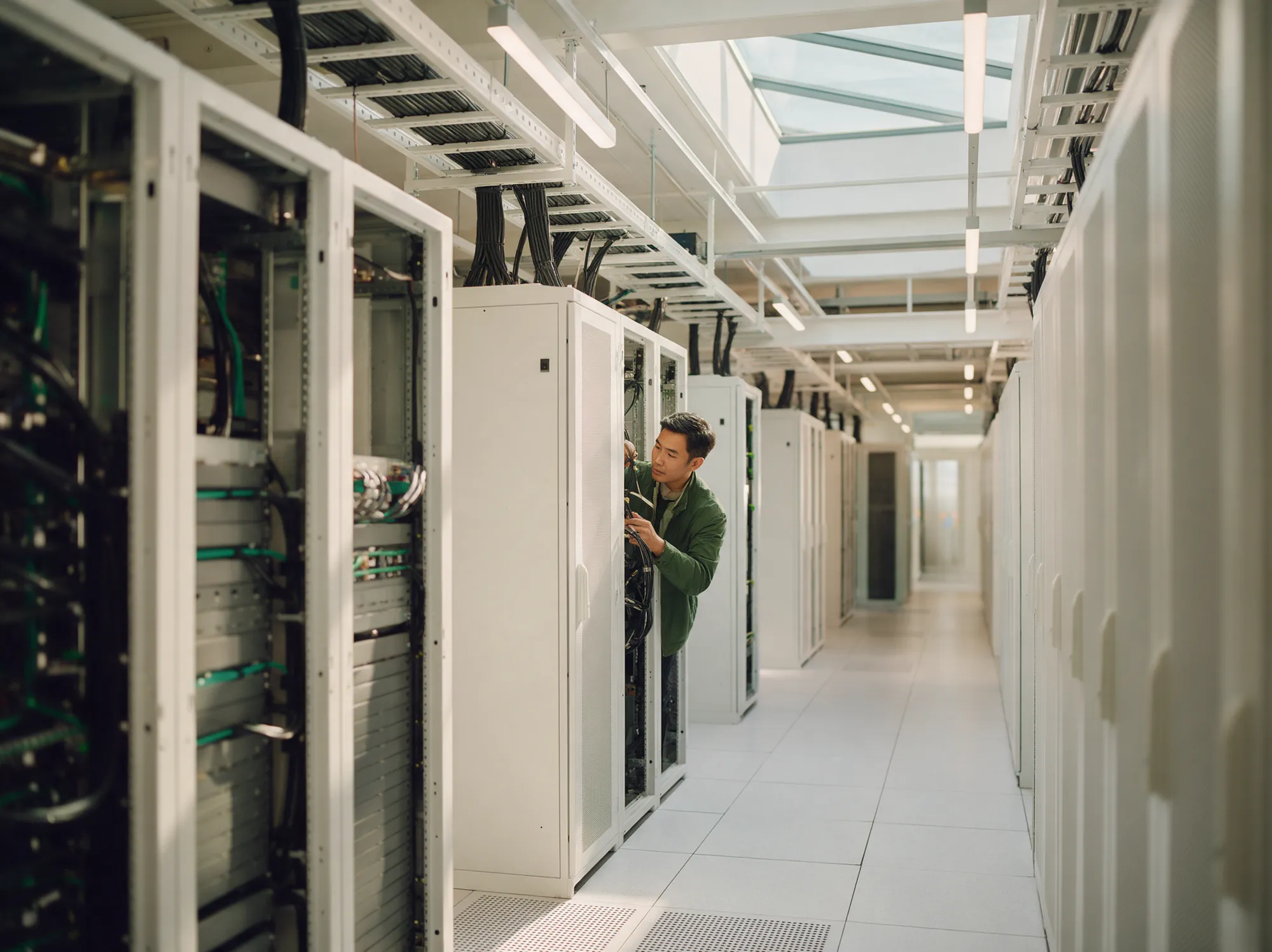 Engineer checking server racks in a bright data centre